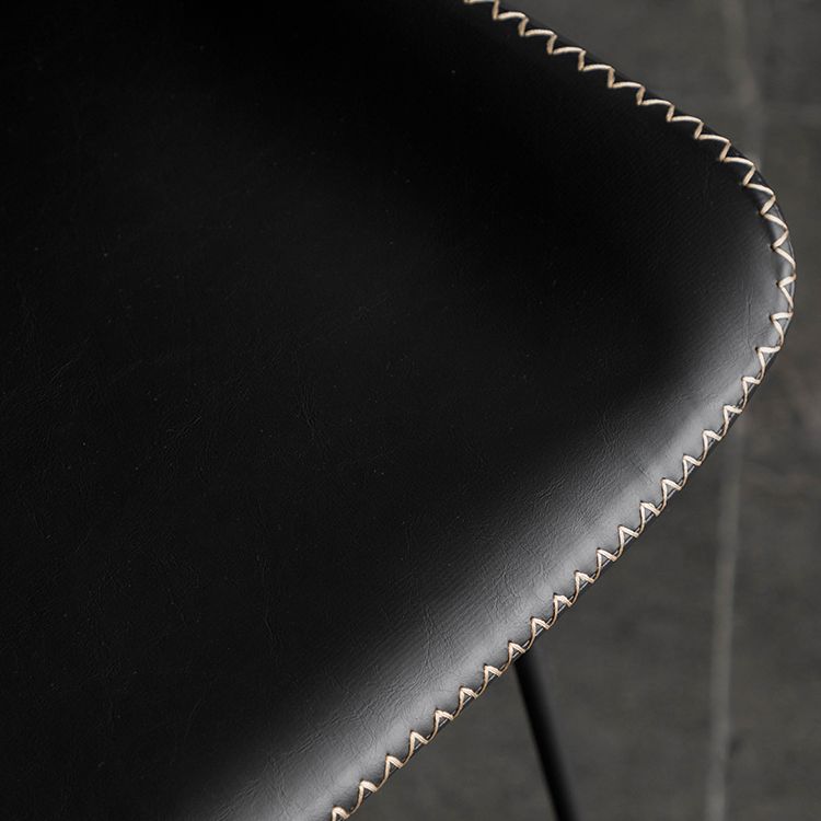 Taburete de barra de hierro industrial en la parte baja de la espalda en interiores altos con asiento de cuero falso