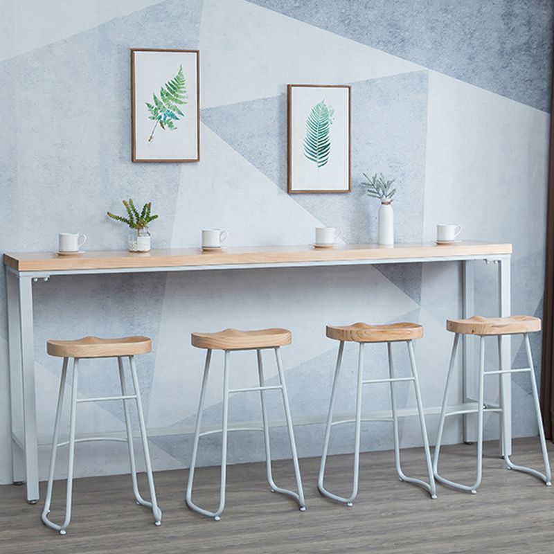Brauner Bartisch aus massivem Holz, weiße Beine und Metallsockel