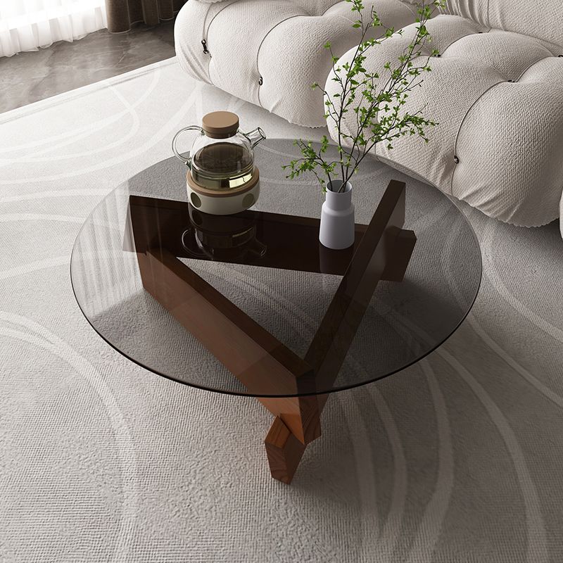 Moderner runder Couchtisch mit Glasplatte und abstraktem Holzbein