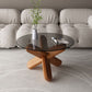 Moderner runder Couchtisch mit Glasplatte und abstraktem Holzbein