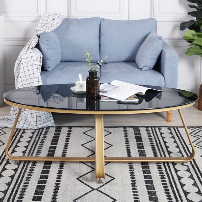 Glam Style Cocktail Table with Oval Top and Golden Iron Cross Base