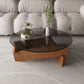 Moderner runder Couchtisch mit Glasplatte und abstraktem Holzbein