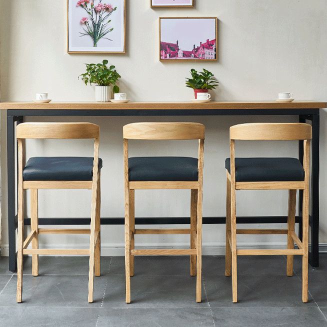 Eigentijdse houten barkruk met lage rugleuning en voetsteunkruk