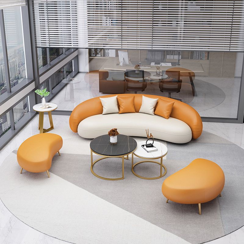 Hedendaagse oranje en witte gebogen bank in leer met hellende armen