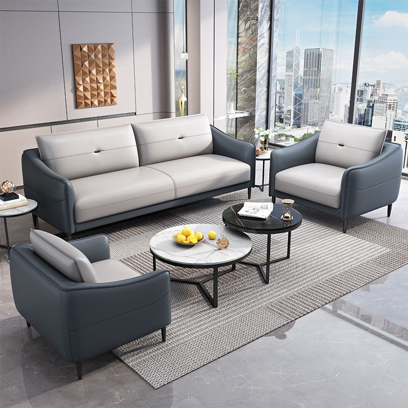 Sofá de cuero gris con cuatro patas sueltas de estilo nórdico de espalda