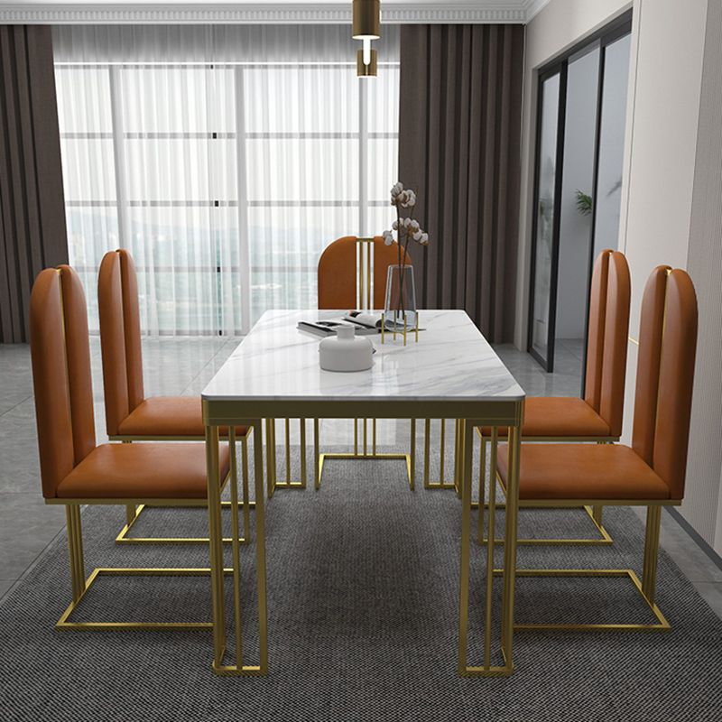 Esstisch im Glam-Stil mit Steinplatte und goldenem Sockel für das Wohnzimmer