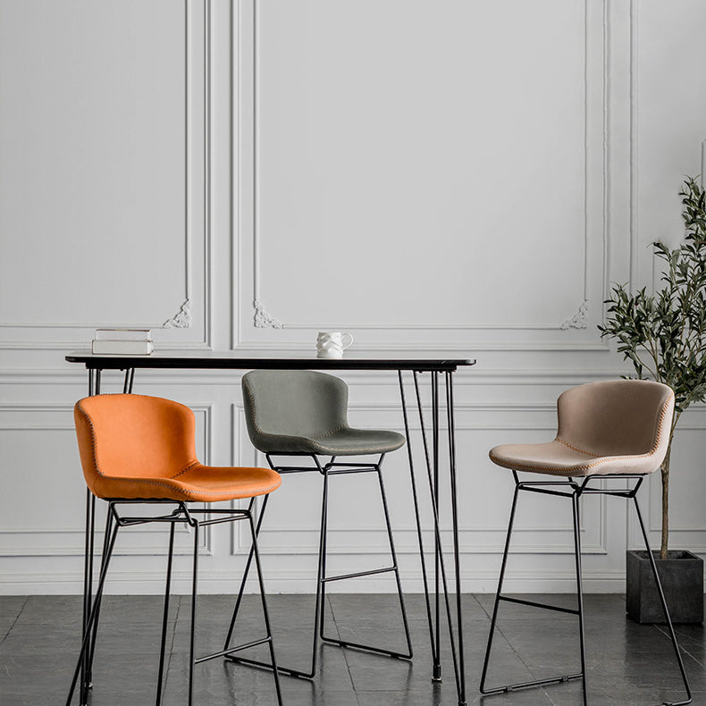 Taburete de barra de hierro industrial en la parte baja de la espalda en interiores altos con asiento de cuero falso