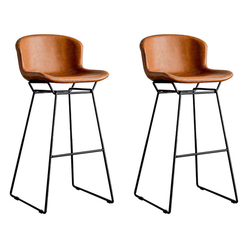 Taburete de barra de hierro industrial en la parte baja de la espalda en interiores altos con asiento de cuero falso