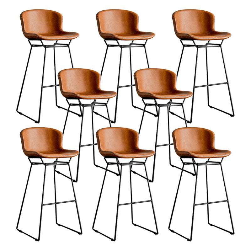 Taburete de barra de hierro industrial en la parte baja de la espalda en interiores altos con asiento de cuero falso