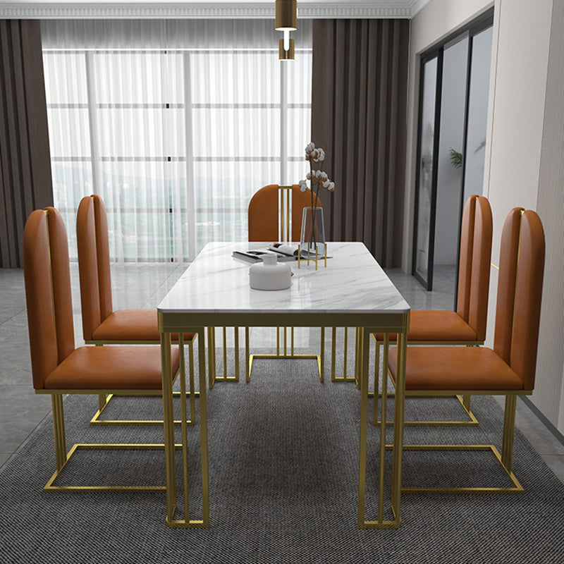 Esstisch im Glam-Stil mit Steinplatte und goldenem Sockel für das Wohnzimmer