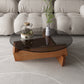 Moderner runder Couchtisch mit Glasplatte und abstraktem Holzbein