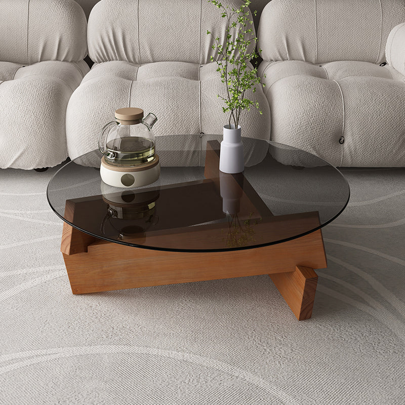 Moderner runder Couchtisch mit Glasplatte und abstraktem Holzbein