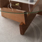 Moderner runder Couchtisch mit Glasplatte und abstraktem Holzbein