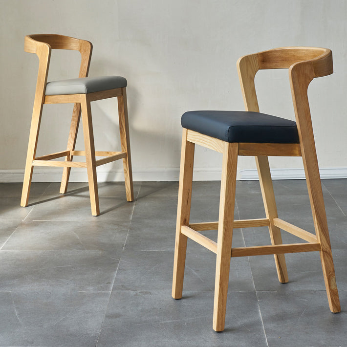 Eigentijdse houten barkruk met lage rugleuning en voetsteunkruk