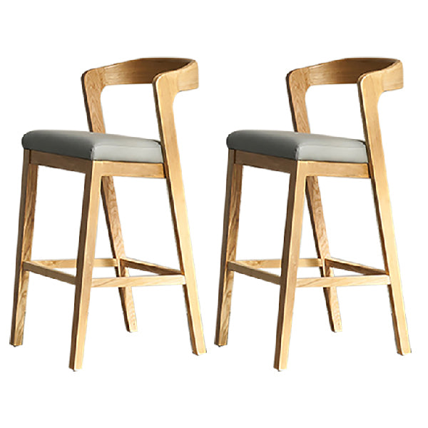 Eigentijdse houten barkruk met lage rugleuning en voetsteunkruk