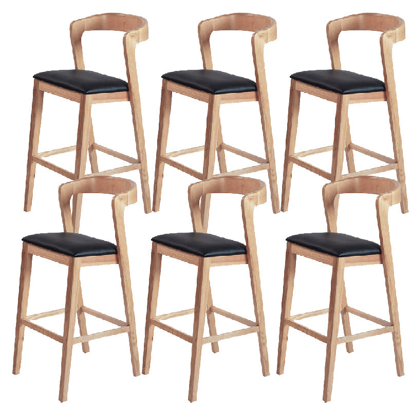 Eigentijdse houten barkruk met lage rugleuning en voetsteunkruk