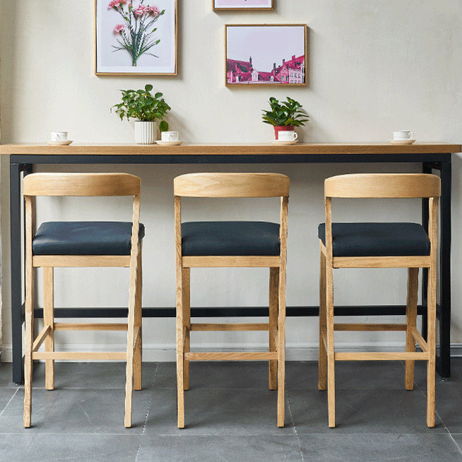 Eigentijdse houten barkruk met lage rugleuning en voetsteunkruk