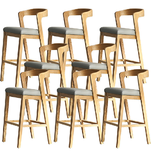 Eigentijdse houten barkruk met lage rugleuning en voetsteunkruk