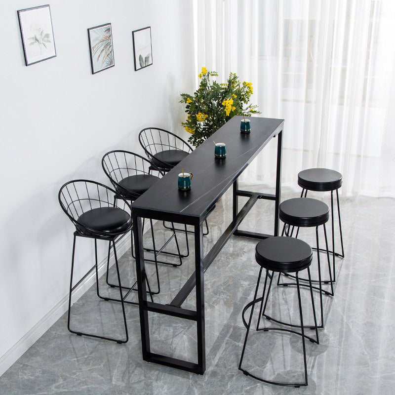 Bistrotisch im Industriestil mit Steinplatte und Metallsockel