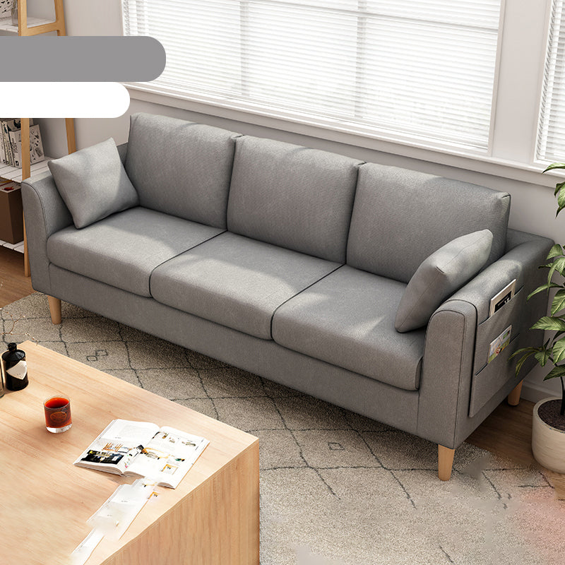 Canapé scandinave de 3 places avec oreillers en dos et bras de smoking et pattes en bois massif