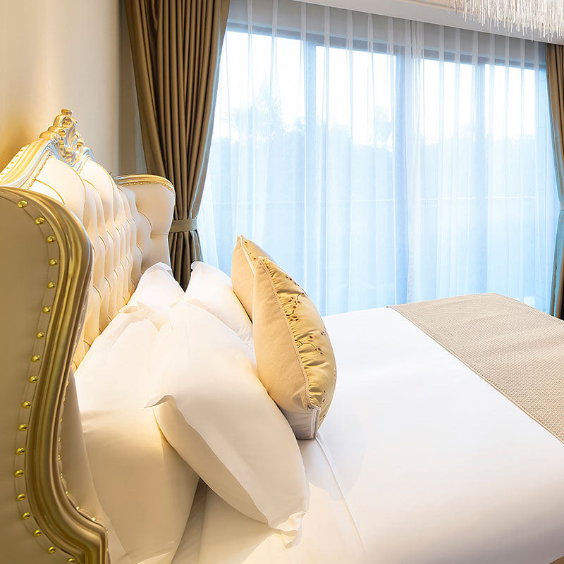 Eigentijds wit bed met gestoffeerd hoofdeinde in Victoriaanse stijl leerhout