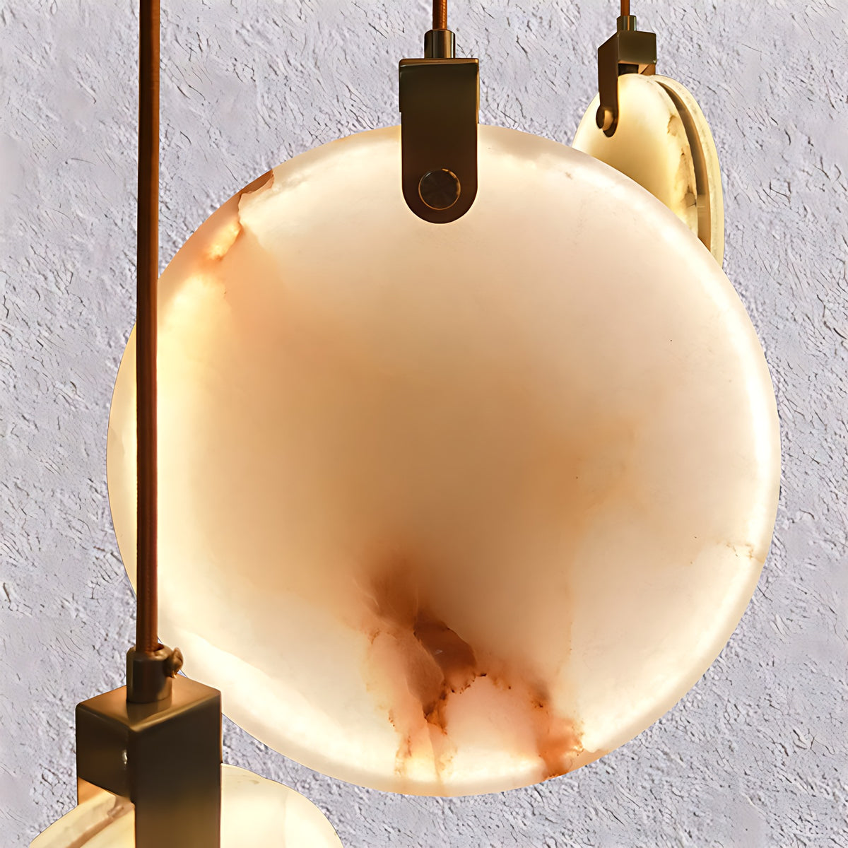 Alabaster Disc Pendant Light, Single or Stair Cluster up to 15 Lights – lit disc close-up, warm veining with brass holder