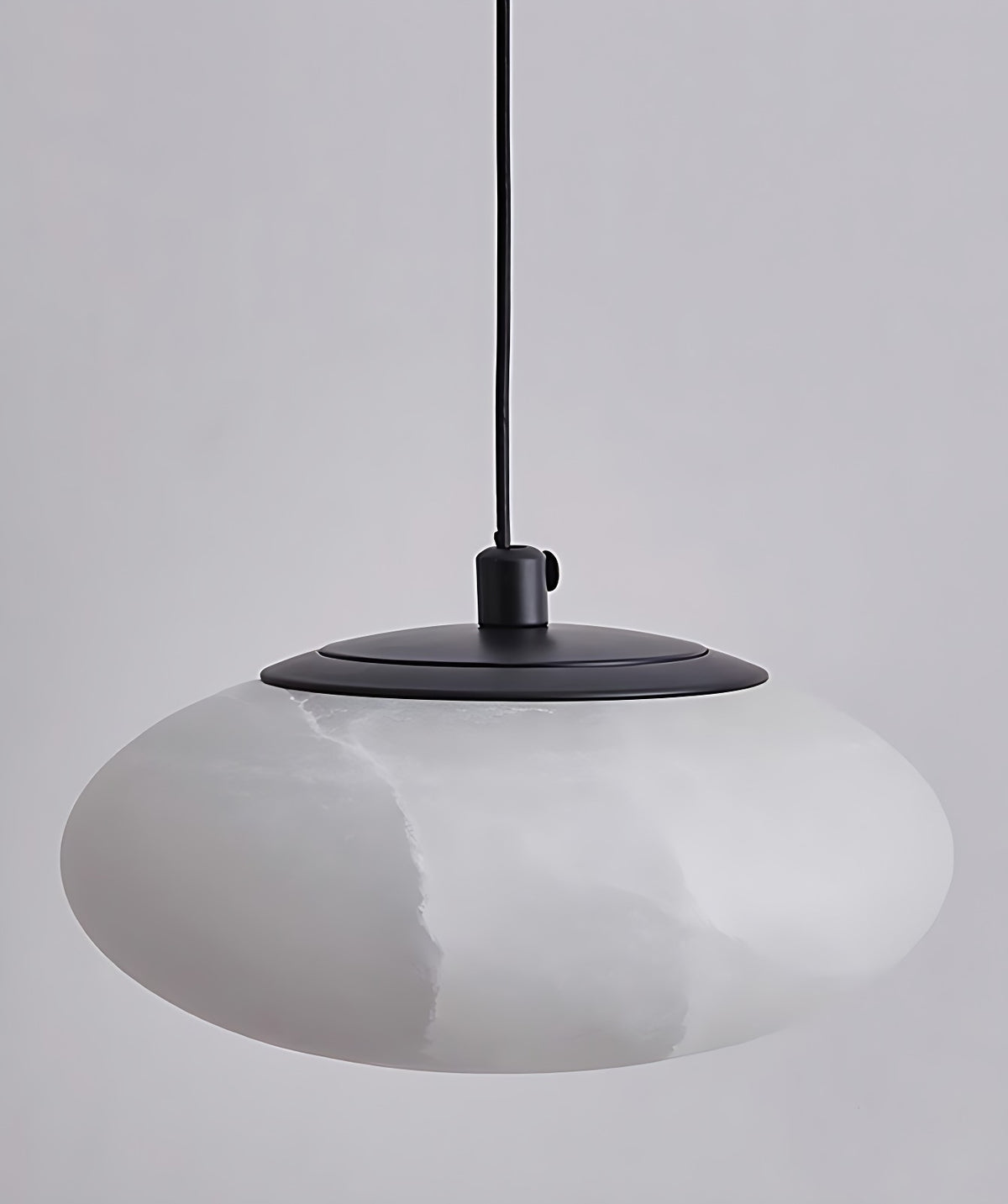 Flat Oval Alabaster Disc Pendant Light with Black Canopy, 4 Sizes – unlit view, white stone with grey veining and black canopy cap, plain grey wall