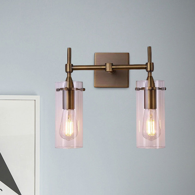 Clear Glass Cylinder Wall Sconce Modern 2 Lights Dining Room Lighting Fixture in Aged Brass Clearhalo 'Cast Iron' 'Glass' 'Industrial wall lights' 'Industrial' 'Middle century wall lights' 'Modern' 'Tiffany' 'Traditional wall lights' 'Wall Lamps & Sconces' 'Wall Lights' Lighting' 1415970