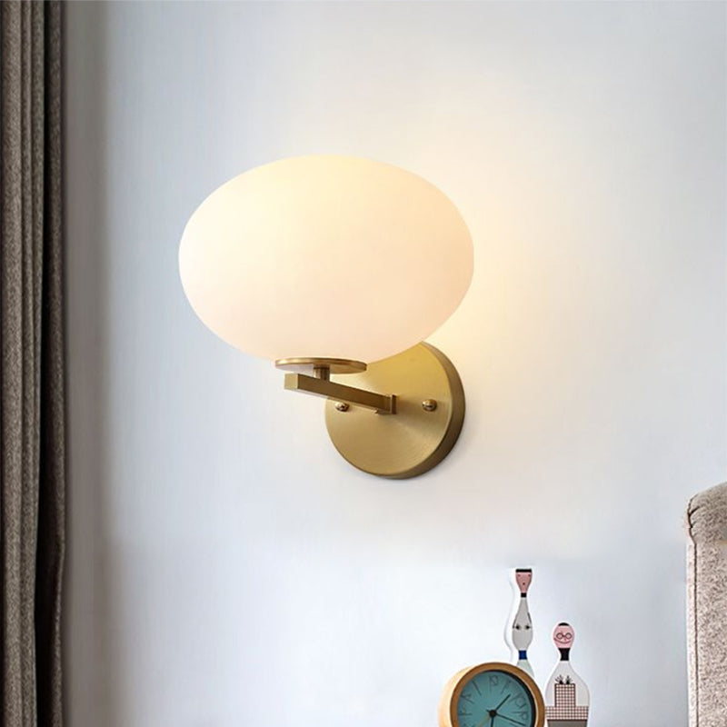 Milk Glass Oval Wall Mount Lamp Modern 1 Light Bedside Wall Sconce Light in Brass Clearhalo 'Cast Iron' 'Glass' 'Industrial' 'Modern wall lights' 'Modern' 'Tiffany' 'Traditional wall lights' 'Vanity Lights' 'Wall Lights' Lighting' 1433701