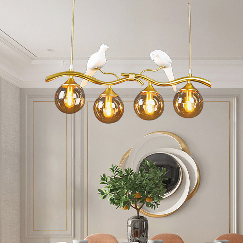 Sprig Island Pendant Light Postmodern Iron 4-Light Black/Gold Hanging Lamp with Amber Ball Glass Shade and Bird Deco Clearhalo 'Ceiling Lights' 'Glass shade' 'Glass' 'Island Lights' Lighting' 1456065