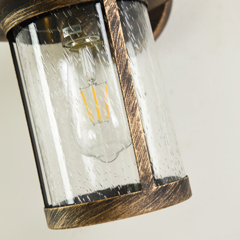 Cylinder Seeded Glass Wall Mounted Lamp Industrial Single Bulb Porch Sconce Light in Matte Black/Bronze with Cage Clearhalo 'Art deco wall lights' 'Cast Iron' 'Glass' 'Industrial wall lights' 'Industrial' 'Middle century wall lights' 'Modern' 'Rustic wall lights' 'Tiffany' 'Traditional wall lights' 'Wall Lamps & Sconces' 'Wall Lights' Lighting' 150072