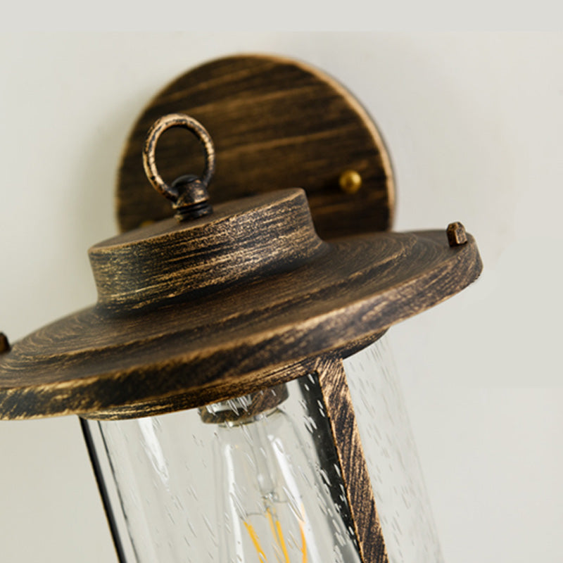 Cylinder Seeded Glass Wall Mounted Lamp Industrial Single Bulb Porch Sconce Light in Matte Black/Bronze with Cage Clearhalo 'Art deco wall lights' 'Cast Iron' 'Glass' 'Industrial wall lights' 'Industrial' 'Middle century wall lights' 'Modern' 'Rustic wall lights' 'Tiffany' 'Traditional wall lights' 'Wall Lamps & Sconces' 'Wall Lights' Lighting' 150073