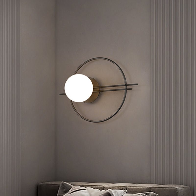 Circle Lounge Sconce Light Iron 1 Head Postmodern Wall Mounted Lighting in Black/Brass with Ball White Glass Shade Black Clearhalo 'Cast Iron' 'Glass' 'Industrial' 'Modern wall lights' 'Modern' 'Tiffany' 'Traditional wall lights' 'Wall Lamps & Sconces' 'Wall Lights' Lighting' 1788578