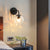 Ball Shaped Wall Lamp Minimalist Clear Rippling Glass 1-Light Bedroom Wall Mounted Lighting with Bent Arm in Black/Gold Black Clearhalo 'Cast Iron' 'Glass' 'Industrial' 'Modern wall lights' 'Modern' 'Tiffany' 'Traditional wall lights' 'Wall Lamps & Sconces' 'Wall Lights' Lighting' 1936631