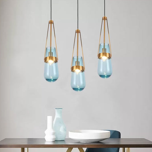 Drop Shaped Dining Room Hanging Lamp Clear/Blue Glass 1 Light Postmodern Pendulum Light with Gripper in Brass Blue Clearhalo 'Ceiling Lights' 'Modern Pendants' 'Modern' 'Pendant Lights' 'Pendants' Lighting' 1937114