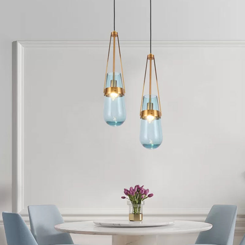 Drop Shaped Dining Room Hanging Lamp Clear/Blue Glass 1 Light Postmodern Pendulum Light with Gripper in Brass Clearhalo 'Ceiling Lights' 'Modern Pendants' 'Modern' 'Pendant Lights' 'Pendants' Lighting' 1937116