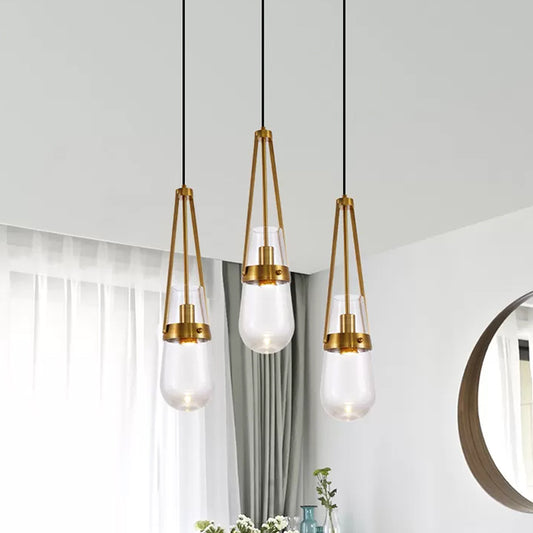 Drop Shaped Dining Room Hanging Lamp Clear/Blue Glass 1 Light Postmodern Pendulum Light with Gripper in Brass Clear Clearhalo 'Ceiling Lights' 'Modern Pendants' 'Modern' 'Pendant Lights' 'Pendants' Lighting' 1937120