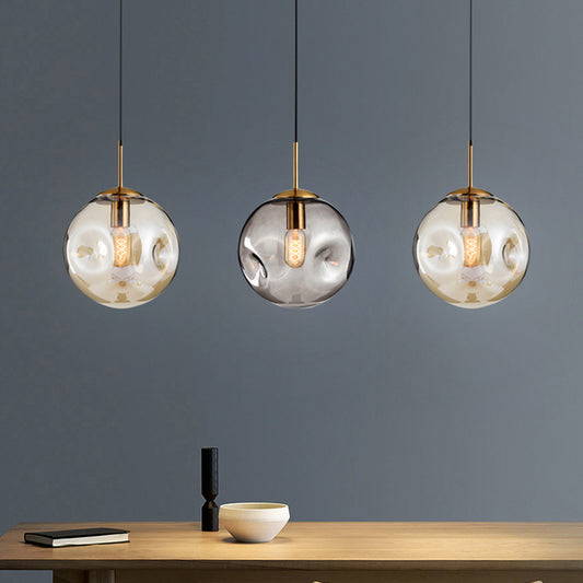 Dimpled Sphere Ceiling Pendant Modern Cognac/Smoke Grey Glass 1 Head Brass Hanging Light Fixture for Living Room Clearhalo 'Ceiling Lights' 'Glass shade' 'Glass' 'Modern Pendants' 'Modern' 'Pendant Lights' 'Pendants' Lighting' 1937208