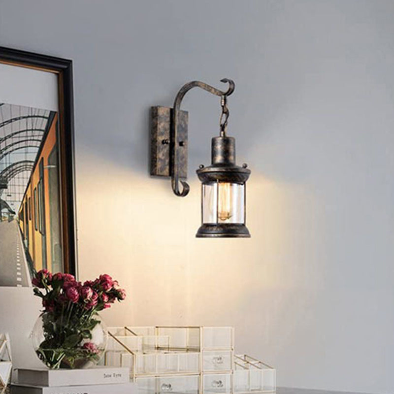 Lantern Wall Mount Light Fixture Coastal Clear Glass 1-Light Dining Room Wall Sconce Lighting with Curved Arm Clearhalo 'Art deco wall lights' 'Cast Iron' 'Glass' 'Industrial wall lights' 'Industrial' 'Middle century wall lights' 'Modern' 'Rustic wall lights' 'Tiffany' 'Traditional wall lights' 'Wall Lamps & Sconces' 'Wall Lights' Lighting' 2011534