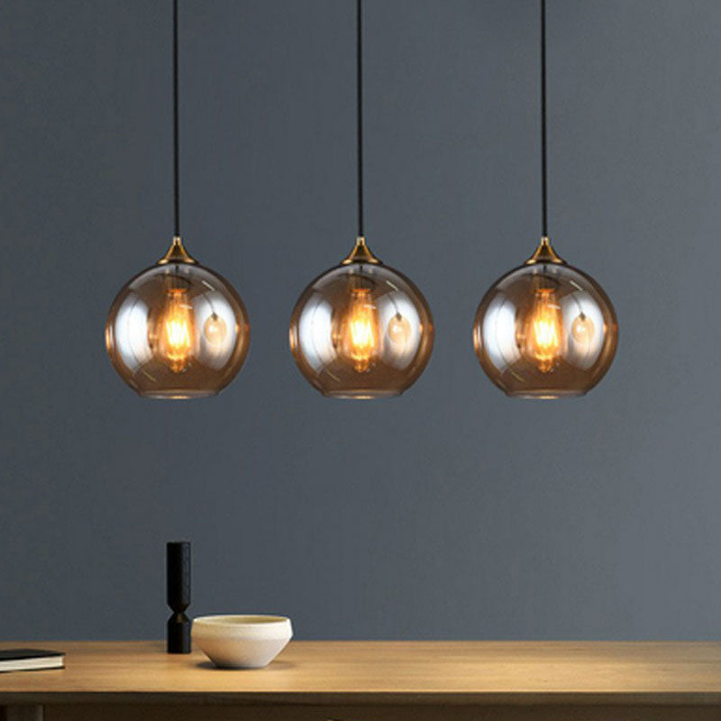 Postmodern 3-Light Pendant Antiqued Brass Globe Multiple Hanging Lamp with Glass Shade Amber Linear Clearhalo 'Ceiling Lights' 'Modern Pendants' 'Modern' 'Pendant Lights' 'Pendants' Lighting' 2266036