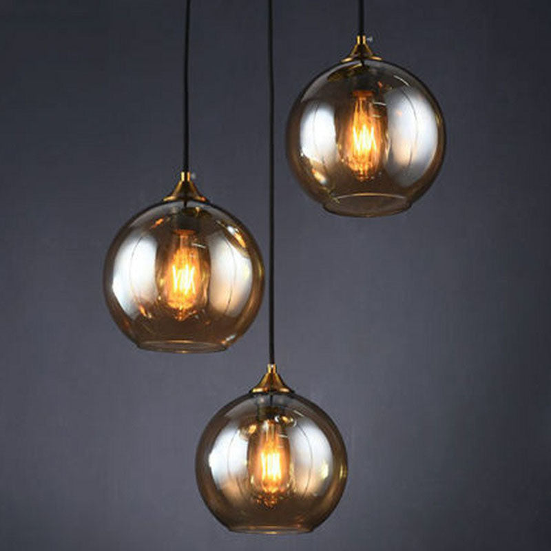 Postmodern 3-Light Pendant Antiqued Brass Globe Multiple Hanging Lamp with Glass Shade Amber Round Clearhalo 'Ceiling Lights' 'Modern Pendants' 'Modern' 'Pendant Lights' 'Pendants' Lighting' 2266038