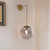 Clear/Smoke Grey Glass Sphere Wall Sconce Retro 1 Light Wall Mount Lamp with Long Gold/Black Arm Gold Clearhalo 'Cast Iron' 'Glass' 'Industrial' 'Modern wall lights' 'Modern' 'Tiffany' 'Traditional wall lights' 'Wall Lamps & Sconces' 'Wall Lights' Lighting' 273156