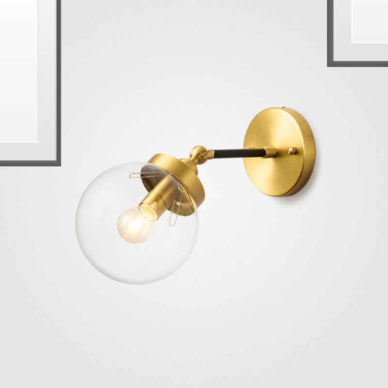 Adjustable Globe Sconce Light Simplicity 1 Bulb Brass Wall Mount Lamp with Transparent Glass Shade Brass Clearhalo 'Cast Iron' 'Glass' 'Industrial' 'Modern wall lights' 'Modern' 'Tiffany' 'Traditional wall lights' 'Wall Lamps & Sconces' 'Wall Lights' Lighting' 275009