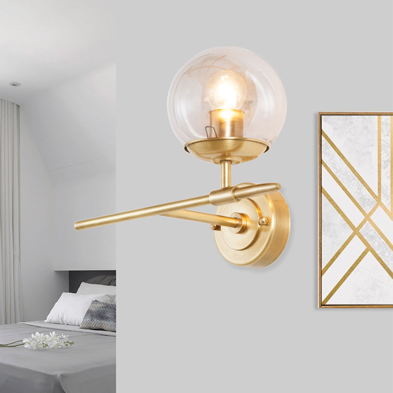 Brass Globe Wall Light Contemporary 1 Light Hand Blown Glass Sconce Light with Crossed Arm Clearhalo 'Cast Iron' 'Glass' 'Industrial' 'Modern wall lights' 'Modern' 'Tiffany' 'Traditional wall lights' 'Wall Lamps & Sconces' 'Wall Lights' Lighting' 275132
