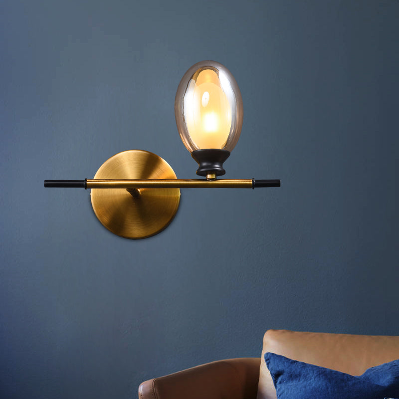 Clear/Amber Glass Egg Shape Wall Light Fixture Minimalist 1 Light Brass Sconce with Horizontal Arm Clearhalo 'Cast Iron' 'Glass' 'Industrial' 'Modern wall lights' 'Modern' 'Tiffany' 'Traditional wall lights' 'Wall Lamps & Sconces' 'Wall Lights' Lighting' 275248