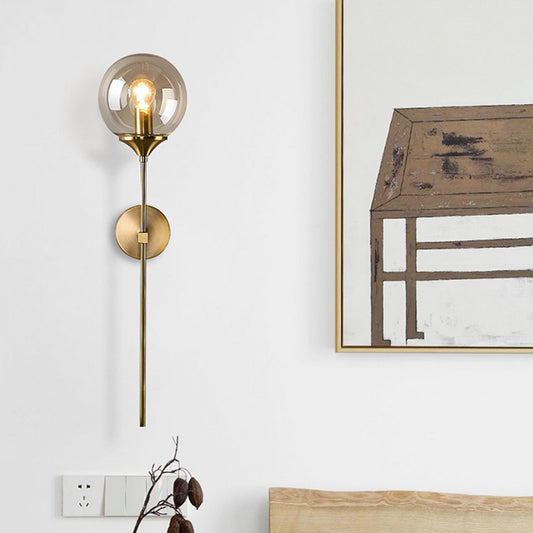 Modernist Round Wall Lamp Clear/Amber/Smoke Gray Glass 1 Bulb Bedside Sconce Light Fixture with Metal Pencil Arm Amber Clearhalo 'Cast Iron' 'Glass' 'Industrial' 'Modern wall lights' 'Modern' 'Tiffany' 'Traditional wall lights' 'Wall Lamps & Sconces' 'Wall Lights' Lighting' 325673