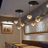 Orb Clear Glass Multi-Light Pendant Modern 3-Light Coffee Shop Hanging Lamp in Black with Linear/Round Canopy Clearhalo 'Ceiling Lights' 'Glass shade' 'Glass' 'Industrial Pendants' 'Industrial' 'Middle Century Pendants' 'Pendant Lights' 'Pendants' 'Tiffany' Lighting' 70094