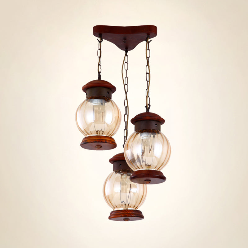 Factory Lantern Cluster Pendant 3-Bulb Tan Glass Suspension Lighting in Copper with Wood Triangle Canopy Clearhalo 'Ceiling Lights' 'Glass shade' 'Glass' 'Industrial Pendants' 'Industrial' 'Middle Century Pendants' 'Pendant Lights' 'Pendants' 'Tiffany' Lighting' 736194