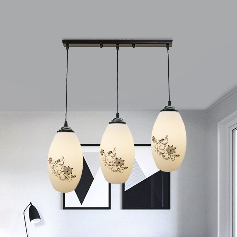 3 Lights Oval Multi-Pendant Modern Black Finish White Printed Glass Ceiling Hang Fixture with Round/Linear Canopy Clearhalo 'Ceiling Lights' 'Close To Ceiling Lights' 'Glass shade' 'Glass' 'Pendant Lights' 'Pendants' Lighting' 802139